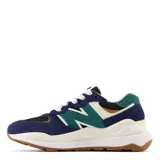 Championes urbanos New Balance con diseño multicolor en tonos azul marino, verde, negro y crema. Presentan una silueta moderna con paneles de gamuza y malla, el logo N característico en los laterales y una suela de plataforma en color blanco con base de goma.