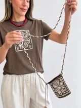 Remera marrón de manga corta y cuello redondo, con estampado floral en un recuadro claro en el frente.