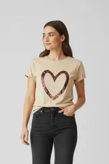 Remera de manga corta con cuello a la base y diseño holgado. Presenta un estampado central en forma de corazón con acabado metalizado tipo foil.