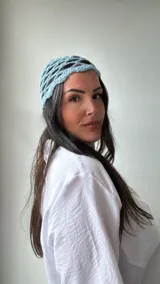 Gorro celeste tejido al crochet con diseño de red.