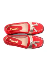 Mocasín de cuero negro con detalle de antifaz plateado y borlas.