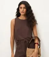 Blusa sin mangas color marrón, con escote redondo y corte recto. Presenta paneles laterales en tejido texturizado con rayas y una abertura vertical en la espalda con cierre discreto.