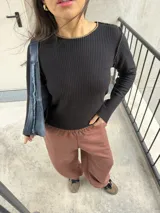Pantalón deportivo estilo baggy de mujer, color chocolate, con cintura elástica y una línea lateral blanca.