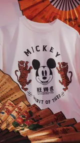 Remera de manga corta y cuello redondo con calce oversize. Presenta un estampado frontal con la cara de Mickey Mouse rodeada por dos tigres y texto alusivo.