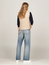 Chaleco acolchado color beige con relleno de plumón, cierre con botones a presión y logo de Tommy Hilfiger bordado en el pecho.