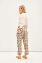 Babucha de voile de algodón con estampado tipo paisley en tonos tierra. Presenta un diseño holgado con lazos internos en el ruedo y botones para ajustar el largo.