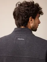 Buzo de abrigo azul melange con cierre frontal completo, cuello alto y bolsillos laterales, confeccionado en mezcla de algodón y poliéster.