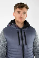 Campera híbrida con cuerpo acolchado en color gris azulado y mangas de felpa gris jaspeado. Cuenta con capucha, cierre frontal y bolsillos con cierres impermeables.