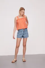 Musculosa blanca con breteles finos y detalles de puntilla.