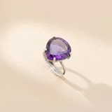 Anillo de plata 925 con piedra amatista natural en forma de corazón, engarzada en una estructura de cuatro garras sobre una banda de plata ajustable.