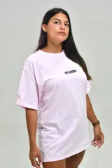 Remera oversize color rosado, con cuello redondo, mangas cortas y estampa frontal con la frase "NO BASIC" en negro.