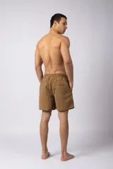 Short de baño de corte relajado en color gris azulado con efecto lavado. Cuenta con cintura elastizada con cordón ajustable, bolsillos laterales y una pequeña etiqueta decorativa en el ruedo.