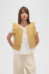 Chaleco corto de algodón con diseño capitoneado, cuello redondo y volados en los hombros.