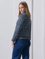 Blazer azul marino de tejido tweed con cuello a la base, apertura central y bolsillos delanteros. Puños con aplique de botones metálicos y terminación desflecada. Forro interno.