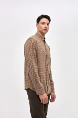 Camisa de corte regular fit confeccionada en algodón, con estampado de cuadros, cuello solapa clásico, cierre frontal con botones y dos bolsillos en el pecho.