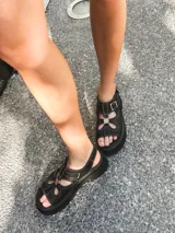 Sandalias negras de cuero vacuno con plataforma track y hebilla lateral.