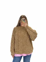 Sweater tejido de punto color beige, con diseño de trenzas y cuello redondo, de manga larga y calce holgado.