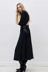 Vestido midi negro de viscosa, con escote redondo, espalda descubierta, mangas largas y frunces en cintura y cuello.