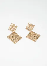Par de aros colgantes dorados con forma de rombo y textura irregular.