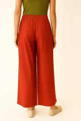 Pantalon de corte ancho y tiro alto, confeccionado en una mezcla de lino y viscosa. Presenta un estampado multicolor con motivos veraniegos y artísticos, cintura elástica con cordón ajustable y bolsillos laterales.