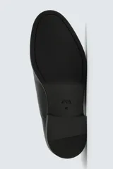Zapato de vestir tipo oxford con puntera reforzada, confeccionado en piel lisa de color negro. Presenta cierre de cordones, forro interior y plantilla de piel, y suela con tacón bajo.