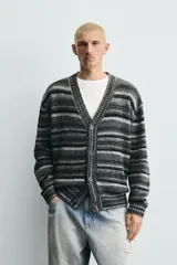Cárdigan de punto con diseño de rayas horizontales en tonos grises y negros. Presenta un corte relajado, cuello en pico, cierre frontal con botones y acabados en rib en puños y bajo.