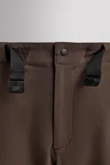 Pantalón de hombre color marrón oscuro, corte regular fit, confeccionado en tejido técnico compacto elástico. Presenta cintura ajustable con cinturón negro a contraste, bolsillos frontales, bolsillo trasero con cierre y bolsillo cargo con cierre en la pernera.