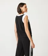 Blusa negra de viscosa con escote redondo y sisa contrastante en color blanco. Sin estampado.