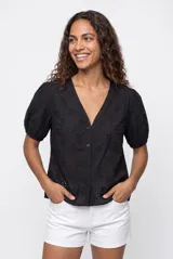 Blusa negra de broderie con escote en V y cierre frontal de botones, mangas cortas abullonadas y diseño holgado.