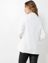 Blazer blanco de crepe, marca BBJ, con cuello solapa, bolsillos delanteros y mangas tres cuartos con frunce. Cuenta con forro interno y diseño abierto al frente.