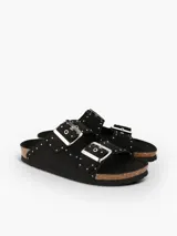 Sandalia plana Genuins modelo Honolulu, de color negro con tachas metálicas decorativas. Cuenta con dos tiras ajustables con hebillas plateadas, plantilla anatómica de corcho natural y suela de EVA.