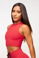 Top deportivo blanco de corte cropped, con cuello alto y logo estampado en el frente.