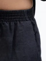 Short de lino color negro, con cintura elástica y bolsillos laterales, de diseño holgado y cómodo.