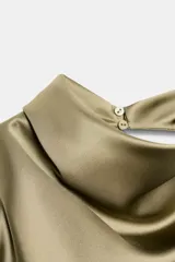 Top de cuello halter con espalda descubierta, confeccionado en tejido satinado con caída fluida y cierre trasero con botones ocultos.