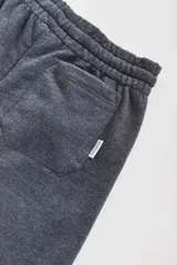 Bermuda de algodón y poliéster en color gris melange, con cintura elástica y bolsillos laterales. Presenta una etiqueta pequeña con el logo de la marca en el bolsillo trasero.