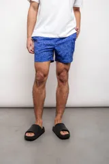 Short de baño azul con estampado de hojas en tonos grises, con cordón ajustable en la cintura, bolsillos laterales y suspensor interior.