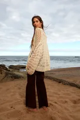 Sweater tejido a mano de algodón color crudo, de calce holgado, con cuello a la base y puños ajustados.