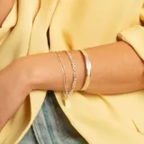 Pulsera de plata 925 compuesta por una cadena de eslabones trenzados y una cadena fina con pequeñas esferas, acompañada de un brazalete rígido de acabado cepillado.