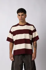 Remera de tejido de punto con diseño de rayas horizontales anchas en color bordó y crema, de corte holgado y cuello redondo.