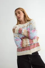 Cardigan de punto con diseño jacquard multicolor, cuello redondo y cierre frontal con botones. Presenta un patrón geométrico y floral en tonos verde, rojo, azul y crema.