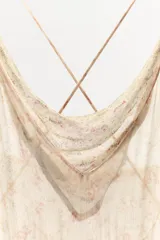 Vestido corto de viscosa con estampado floral, escote drapeado y tirantes finos cruzados en la espalda. Presenta un diseño con bajo asimétrico y acabado fluido.
