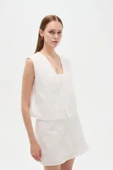 Chaleco blanco sin mangas confeccionado en algodón, con cuello en V y diseño bordado.