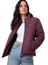 Chaqueta acolchada color bordó con diseño de costuras en zigzag. Presenta cierre frontal central, bolsillos laterales con cierre y logo de la marca en el pecho. Cuenta con cuello alto y puños internos de punto acanalado para mayor protección.