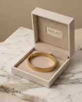 Esclava rígida de acero con baño de oro, con diseño de flores grabadas en toda su superficie.