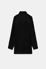 Vestido corto de punto con cuello subido, manga larga y sisa ancha. Presenta un detalle de costura vertical marcada en el centro del delantero y acabados en rib en cuello, puños y ruedo.