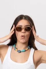 Collar corto con piedras y cuentas en tonos turquesa, azul, amarillo y beige de formas irregulares.