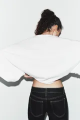 Camiseta de algodón con corte holgado, cuello redondo y mangas anchas tipo capa.