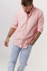 Camisa de hombre color crema, de corte clásico, con cuello abotonado y mangas largas.