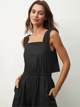 Mono negro con escote cuadrado, sin mangas, corte holgado y cintura elastizada.