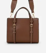 Cartera satchel mediana de color marrón, confeccionada en poliuretano con diseño estructurado, costuras en contraste y herrajes metálicos dorados. Cuenta con doble asa de mano, correas decorativas verticales con hebillas en la parte frontal y una correa larga ajustable y desmontable para llevar al hombro o cruzada.